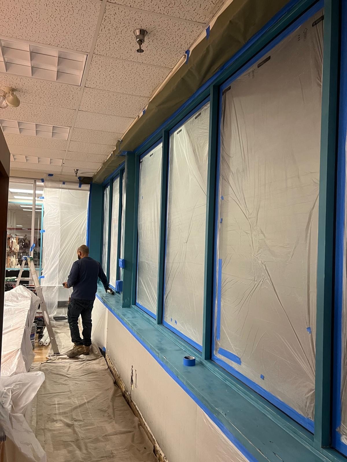 Installing protective window film ahead of an interior retail buildout.